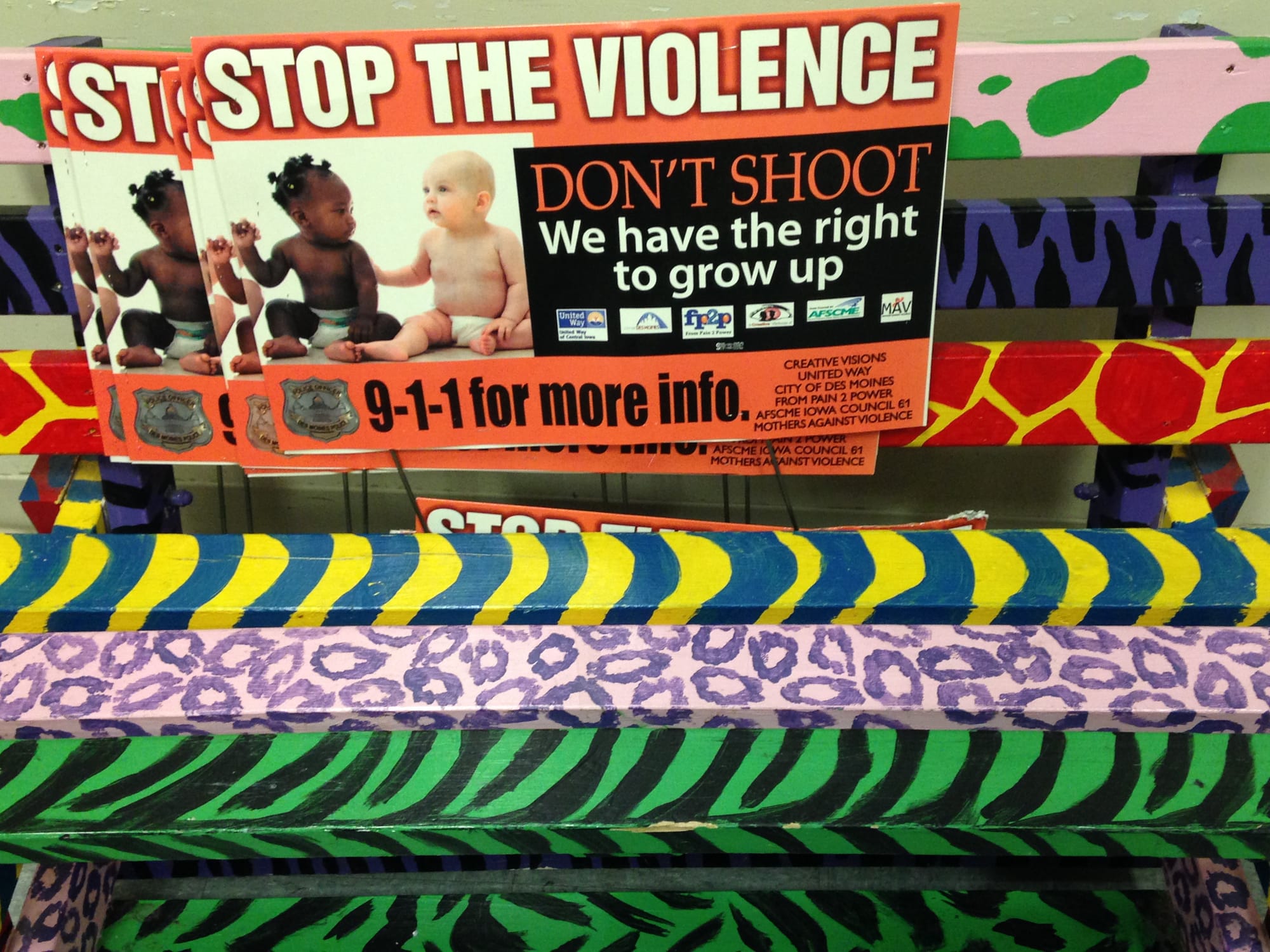 Signs and a bench at Creative Visions promote the organization' s message against violence in northwest Des Moines.