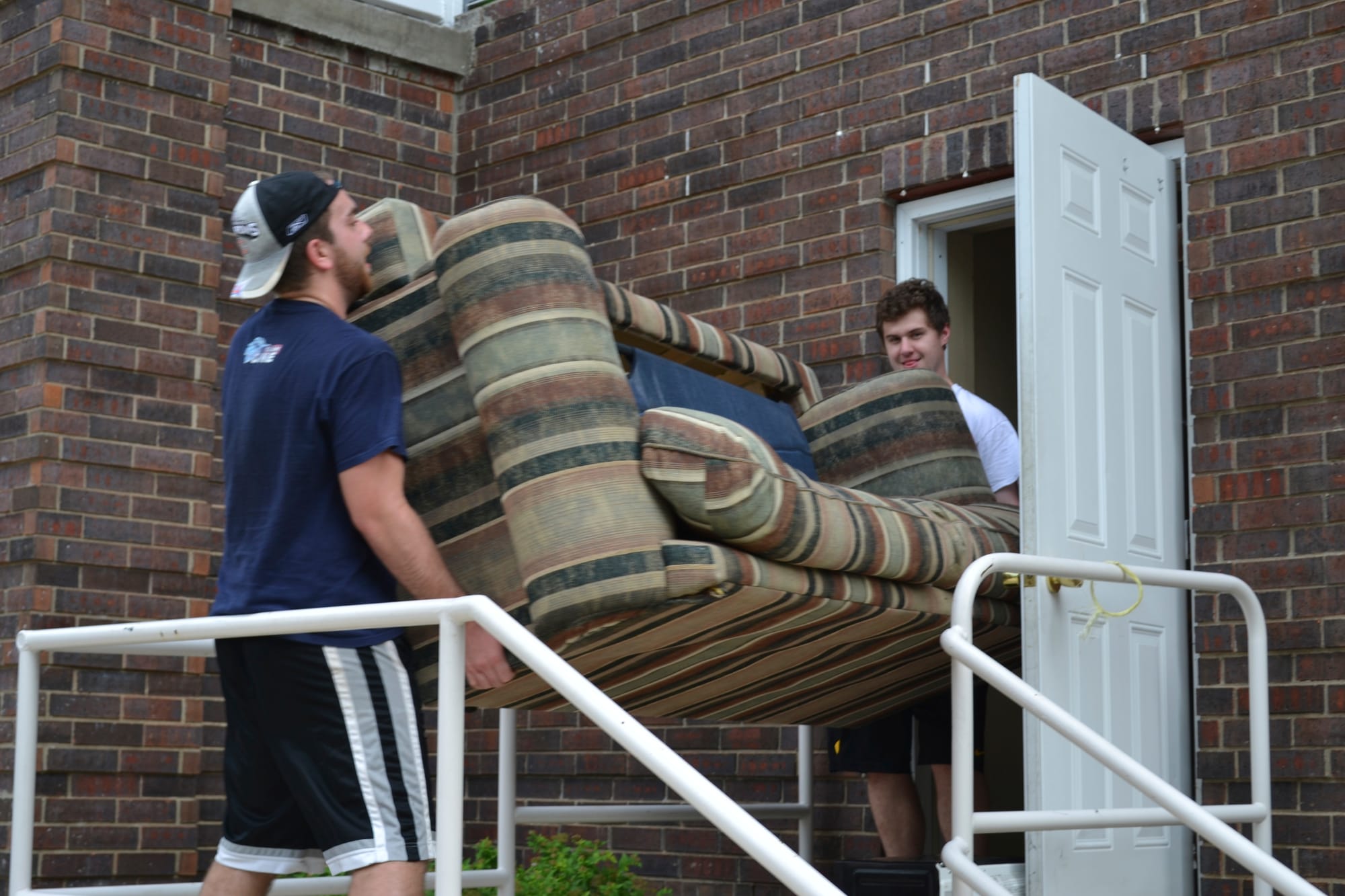 University of Iowa seniors Alec Lombardo, 21, and Steven Moioffer, 20, move furniture out of an apartment on 408 S. Van Buren St. in Iowa City on July 28, 2015. Leases for apartments students typically rent usually expire on July 31 each year.
