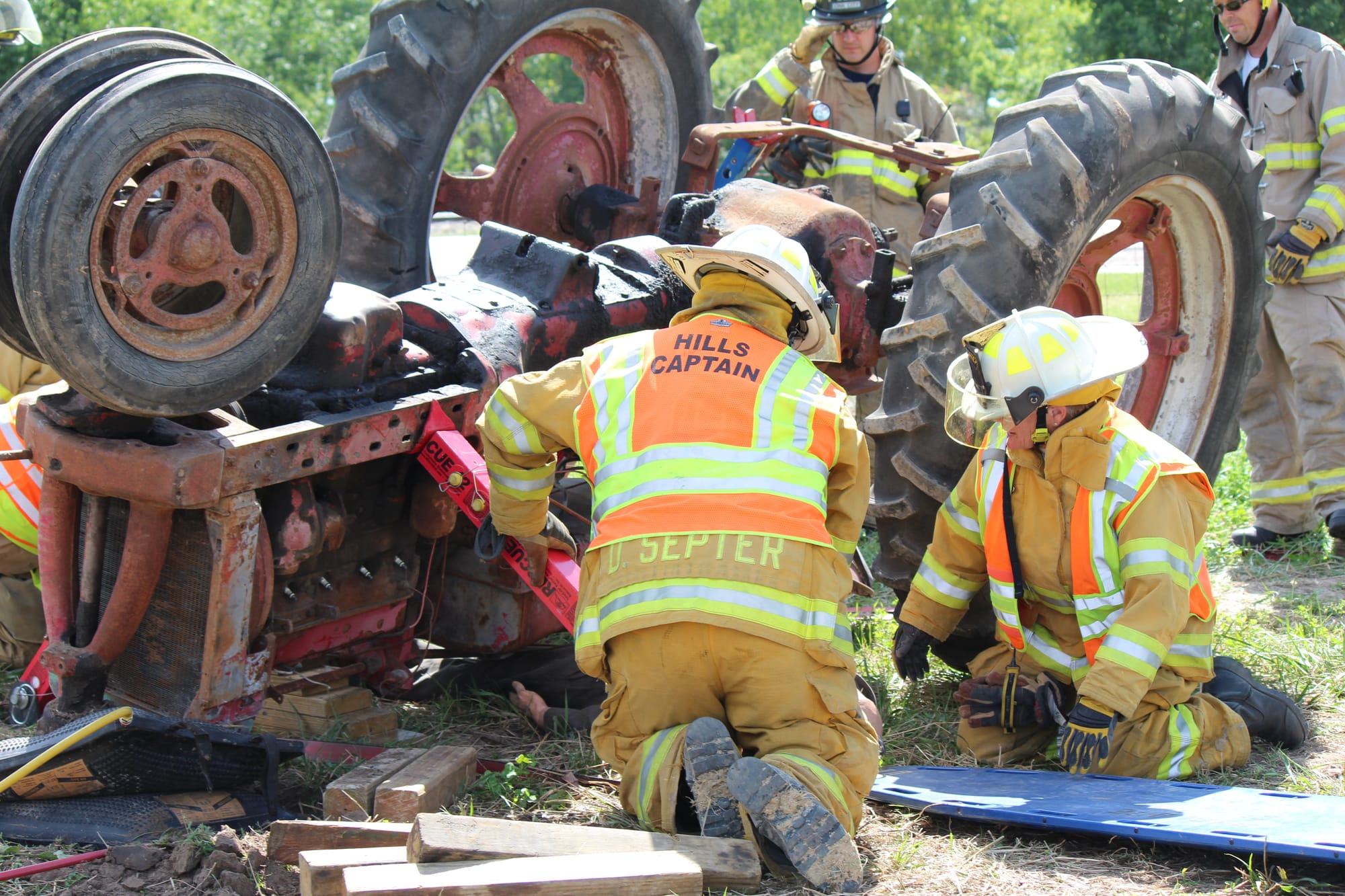 Eastern Iowa firefighters practice their response to a farmer pinned beneath a rolled over tractor in Tractor Rollover Extrication Training, by the Rural Health and Safety Clinic of Greater Johnson County, on Aug. 3 at the Johnson County Extension Building in Iowa City.
