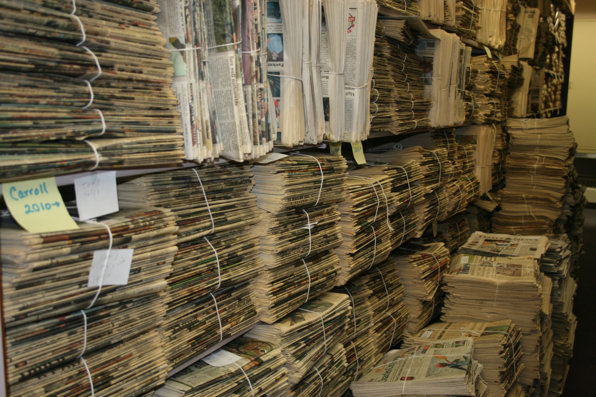 Bundles of daily papers have overflowed onto the floor in the library of the State Historical Building in Des Moines on February 17, 2015.