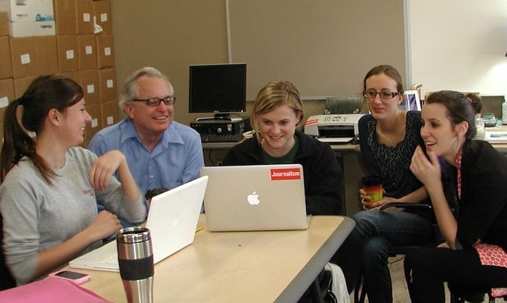 In late 2011, IowaWatch reporters gather around co-founder Stephen Berry discussing stories. Left to right, Emily Hoerner, Berry, Laura Arny, Lauren Mills Shotwell, MacKenzie Elmer.
