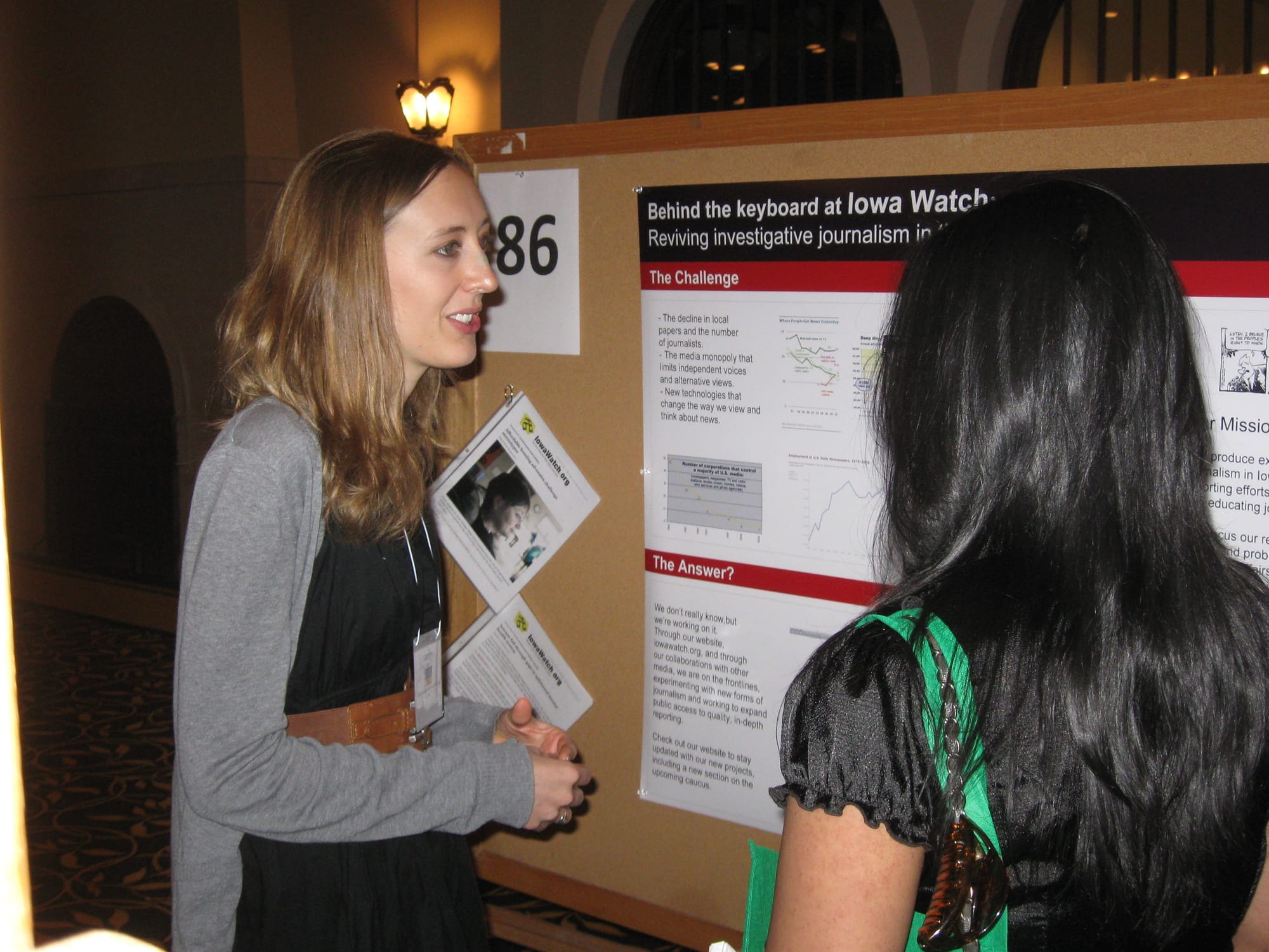 Lauren Mills discusses her Iowa Watch posters with one of a festival judge. Source: Cheryl C. Berry
