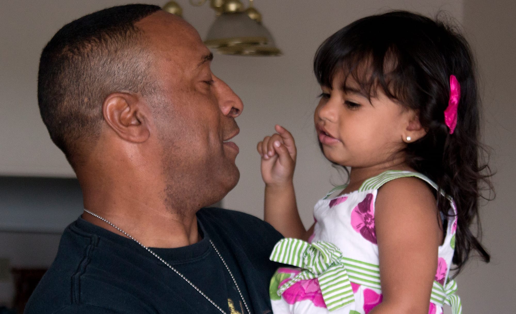 Stephen Leon, a combat veteran who is now 70 percent disabled, holds his granddaughter Ashley A. De Leon at his apartment in Revere, Mass. in June.