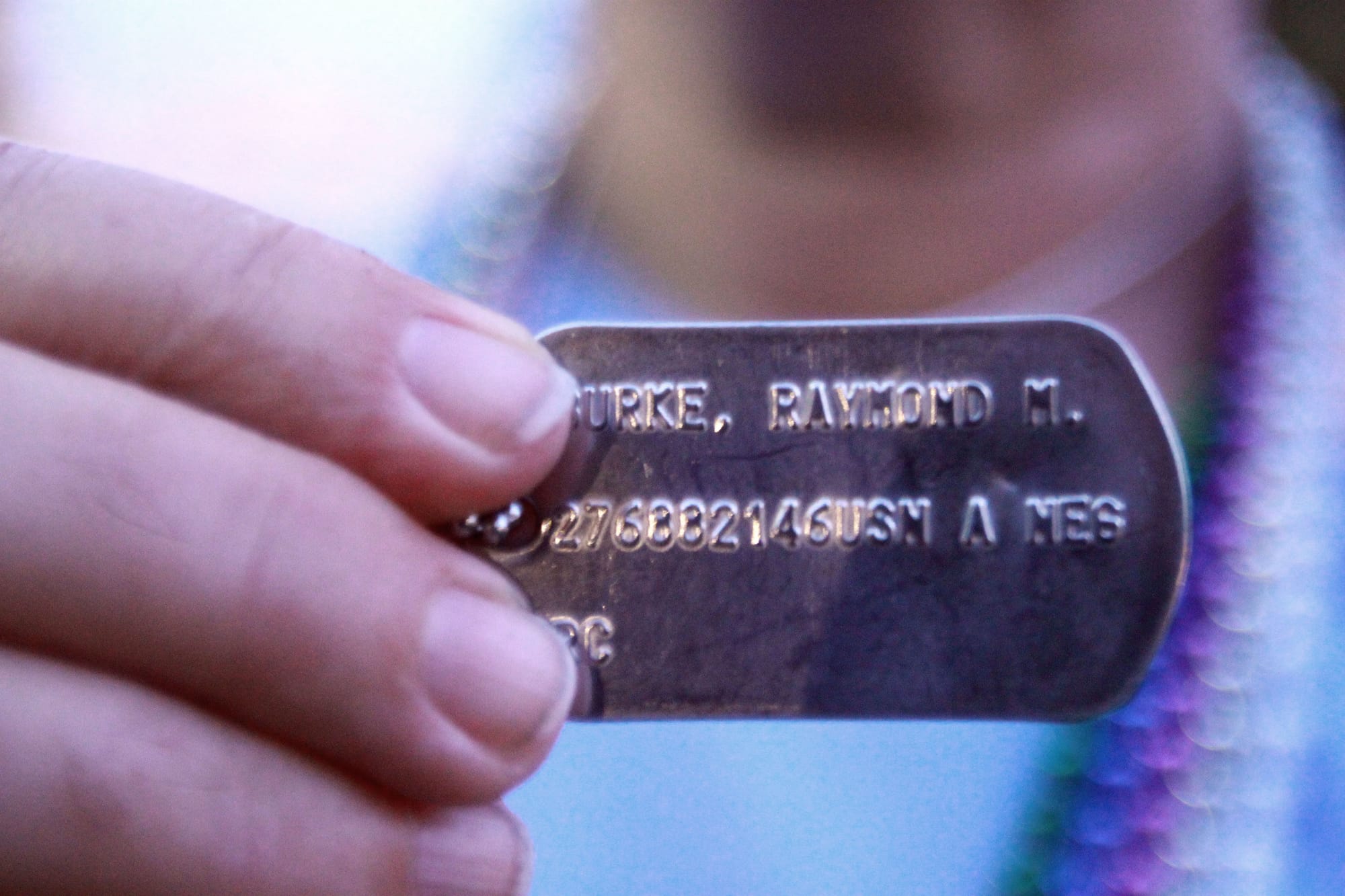 Mary Anne Burke, of Chantilly, Va., holds her son's dog tag after completing a 16-mile walk throughout downtown Washington, D.C., in June 2013. Burke's son, Raymond Matthew Burke, died by suicide in 2001 while on leave from his naval station.