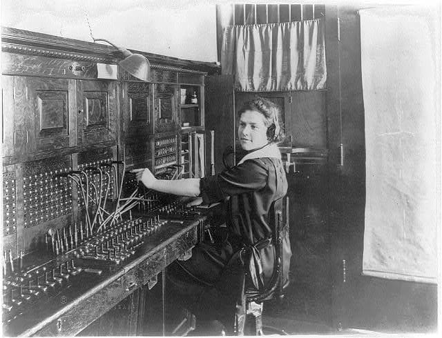 Young woman seated at switchboard circa 1922.