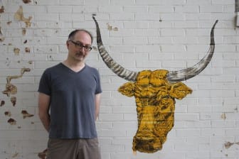 Todd Thelen, the owner of Artifacts, and a piece of graffiti on his building in Iowa City.