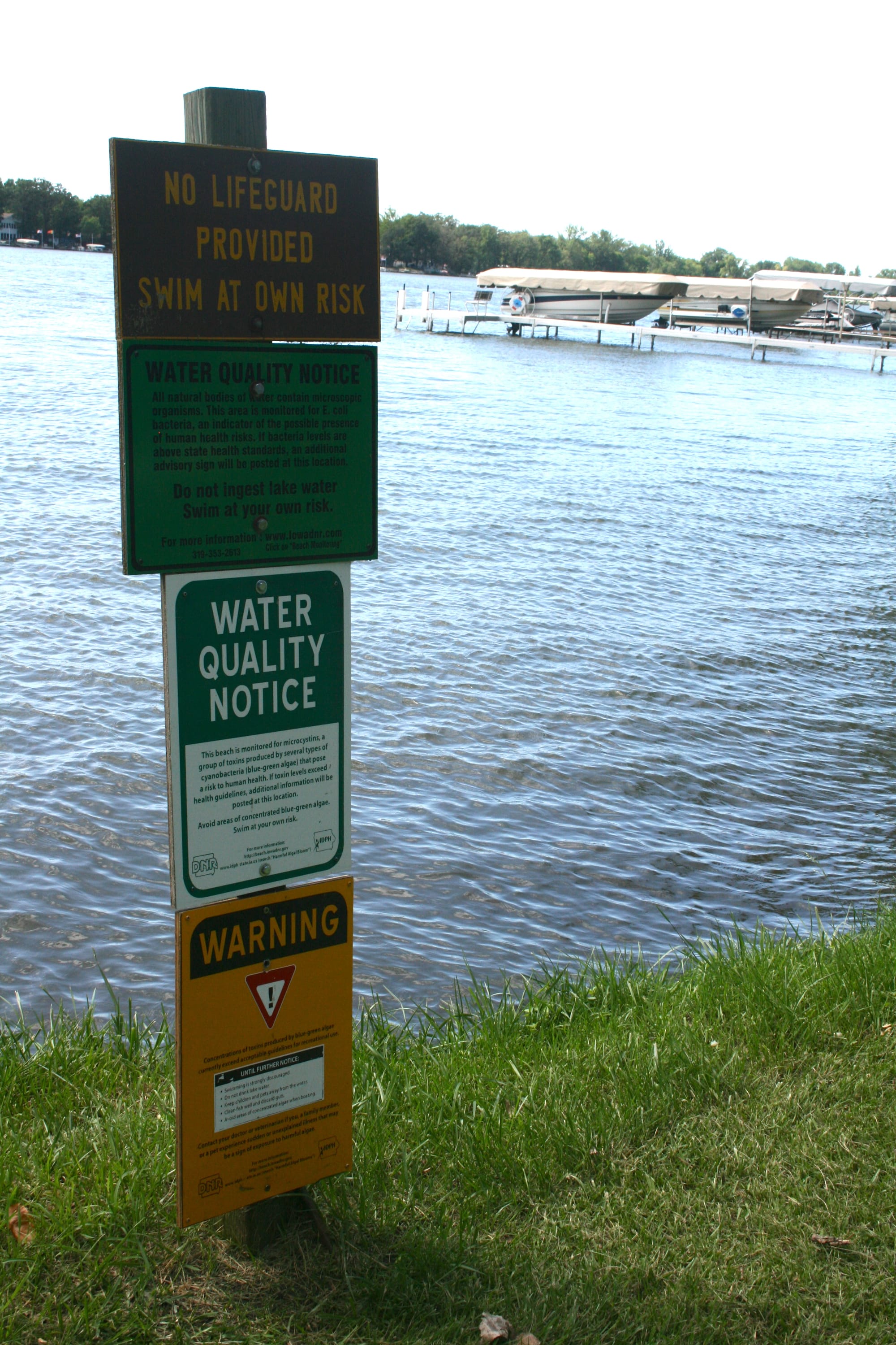 A yellow sign at the base warns swimmers of high levels of microcystin, a liver toxin produced by cyanobacteria in the North Twin Lake on July 30, 2015.