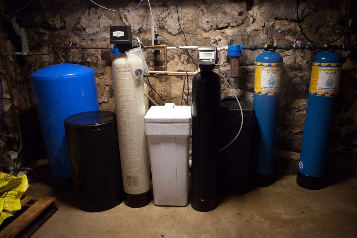 The water filtering system in the basement of Doug and Dawn Reeves' home near Stoughton, Wis., shows the efforts the couple has made to remove atrazine and other contaminants from their drinking water. That includes two small blue tanks that remove sediments, the black tank that removes nitrate, and two large blue tanks to remove volatile organic compounds, herbicides and pesticides. The large blue filters cost the Reeves family $1,500 a piece. There also is a reverse osmosis filter attached to the kitchen faucet.