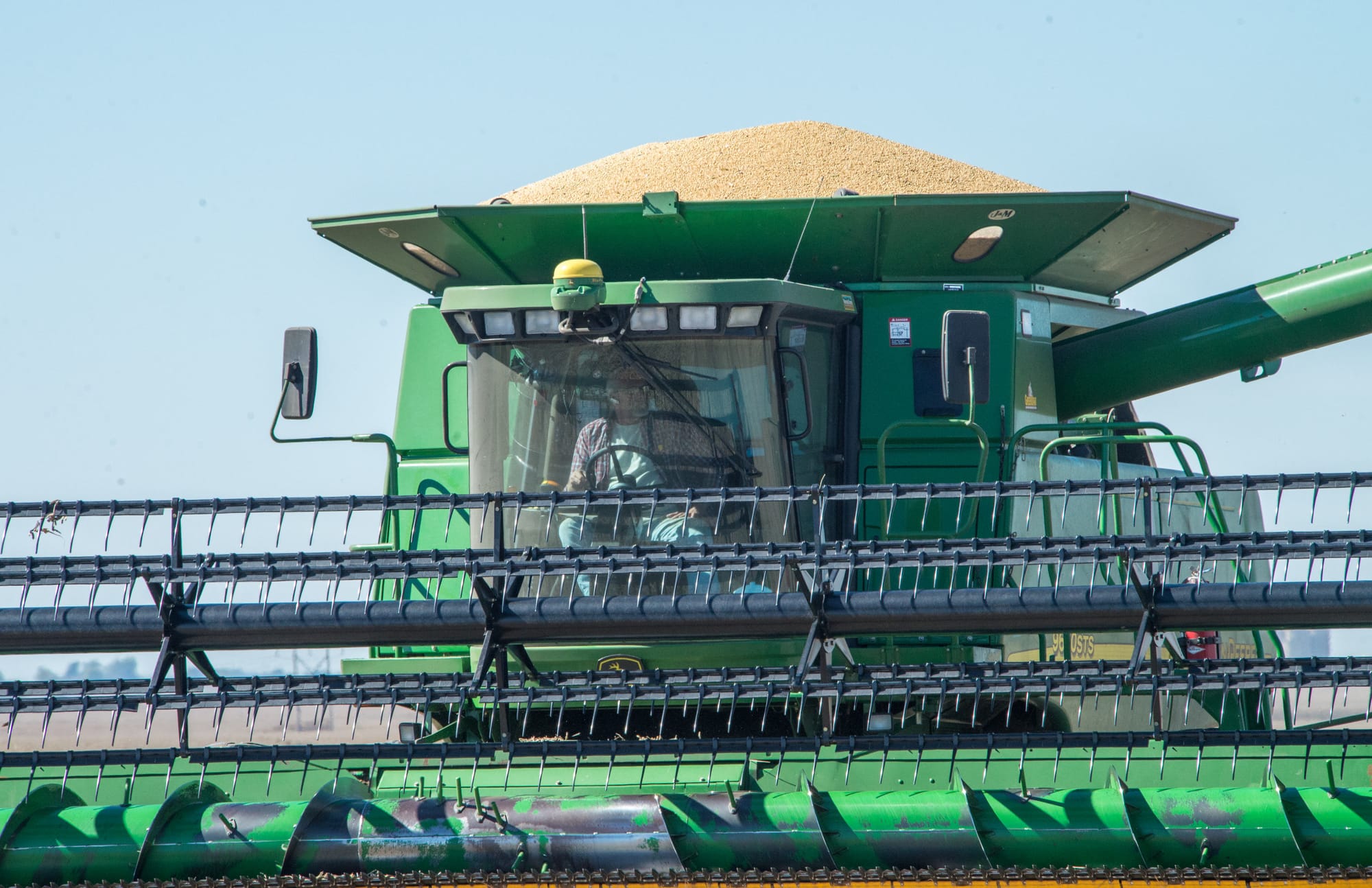 A combine with a full hopper of soybeans heads to a waiting truck at a harvest just north of Mansfield, Ill., on Wednesday, Oct. 9, 2013.