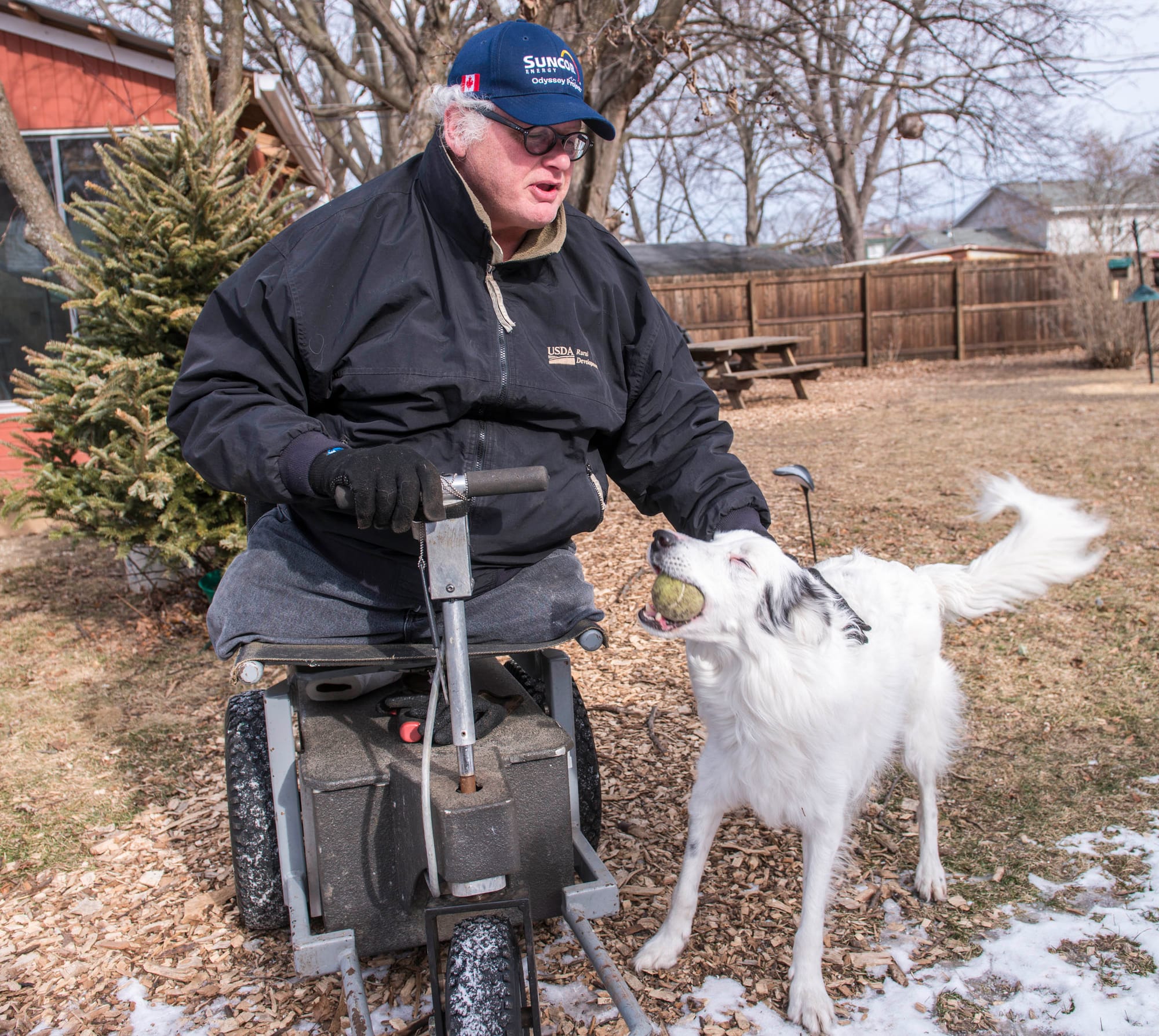 Chip Petrea greets his dog Laddie in his backyard at home in Urbana, Ill.