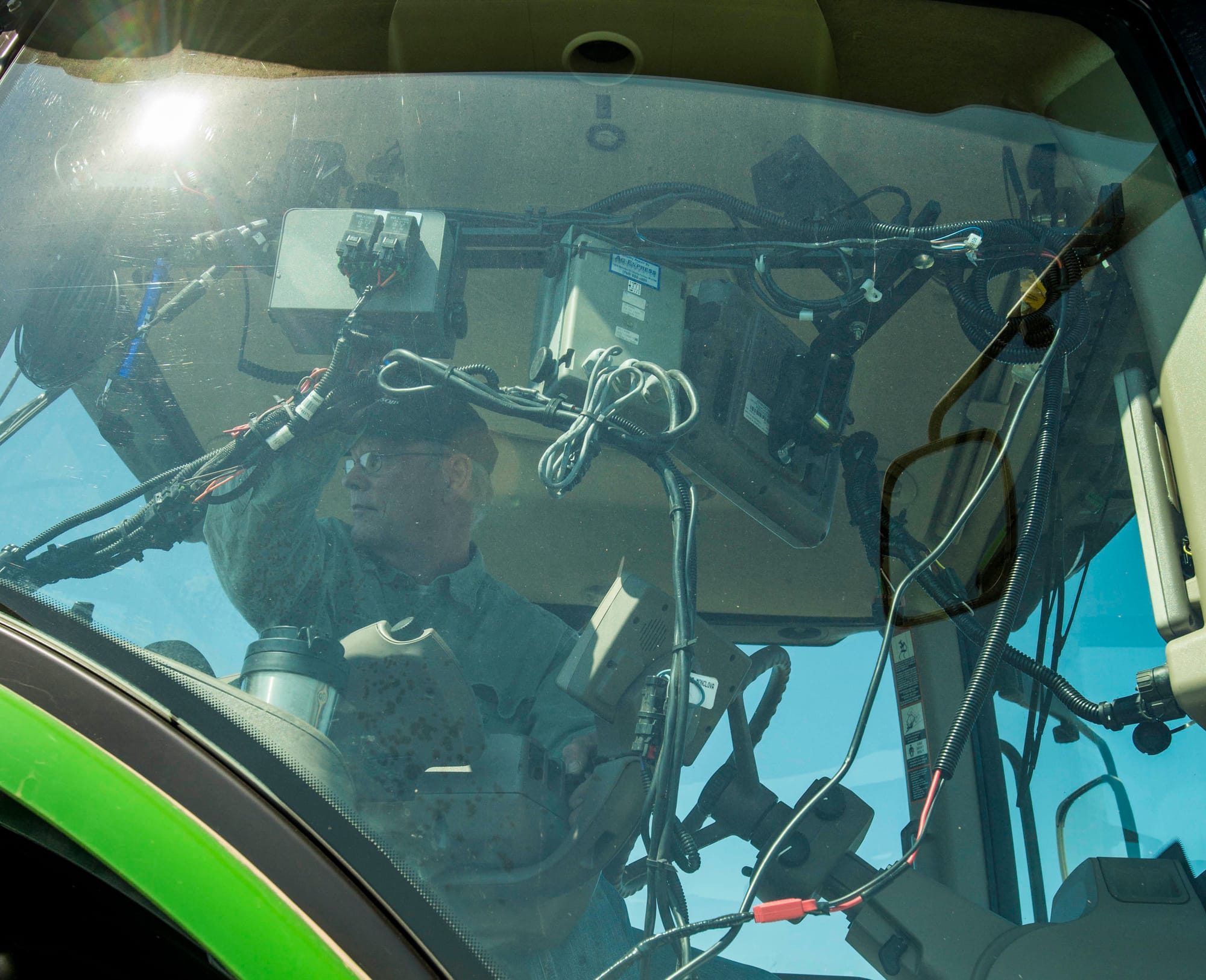 An Illinois farmer looks at electronics in the cab of his tractor on April 19, 2014.