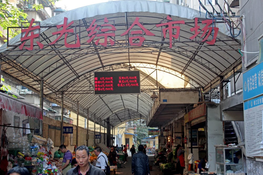 People walk through a local market in the city of Chengdu in southwest China.