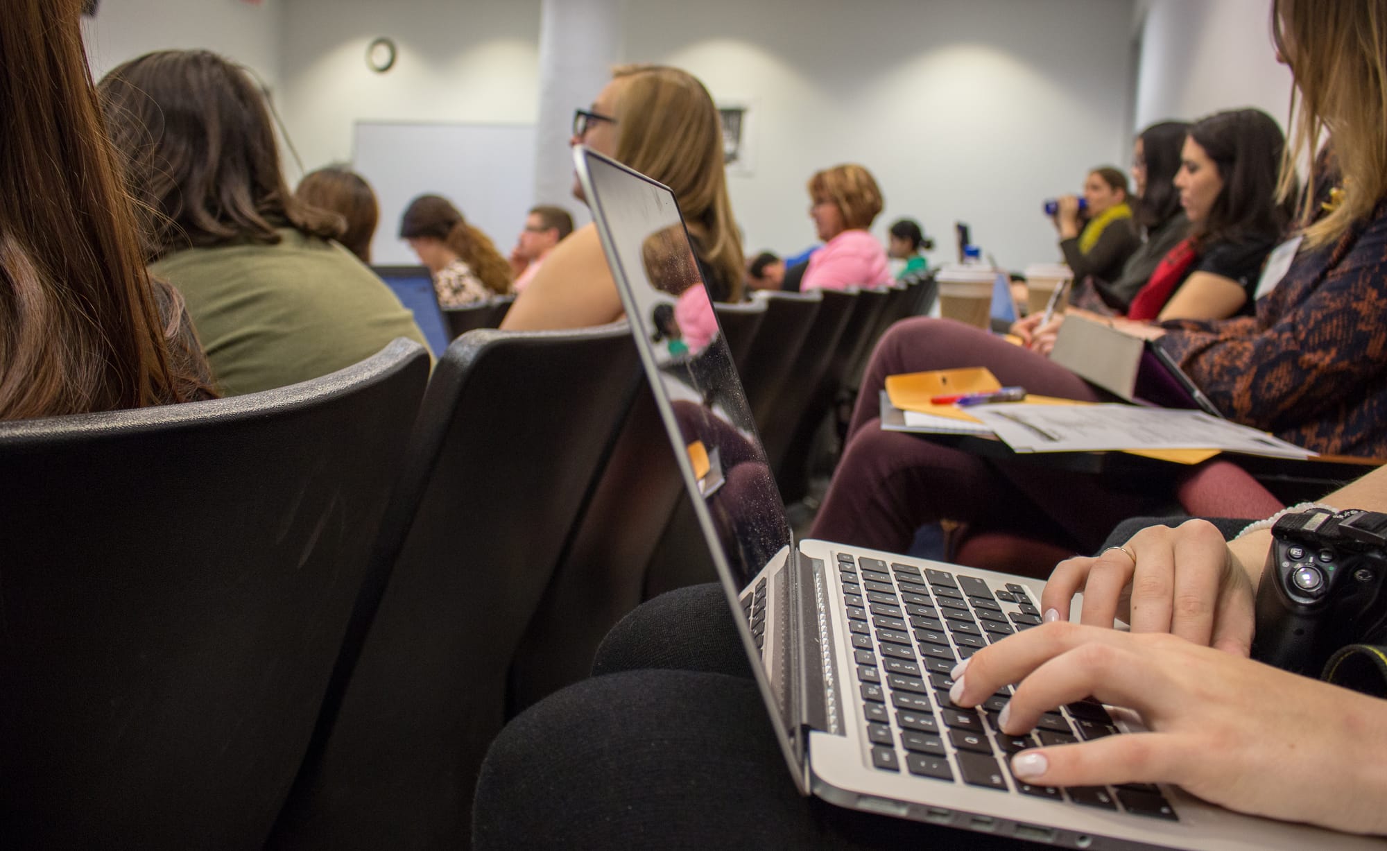 In 2015, the Midwest Center for Investigative Reporting hosted the workshop "Covering the U.S. Visa System in Your Own Backyard." Here, a reporter takes notes during an event session. 