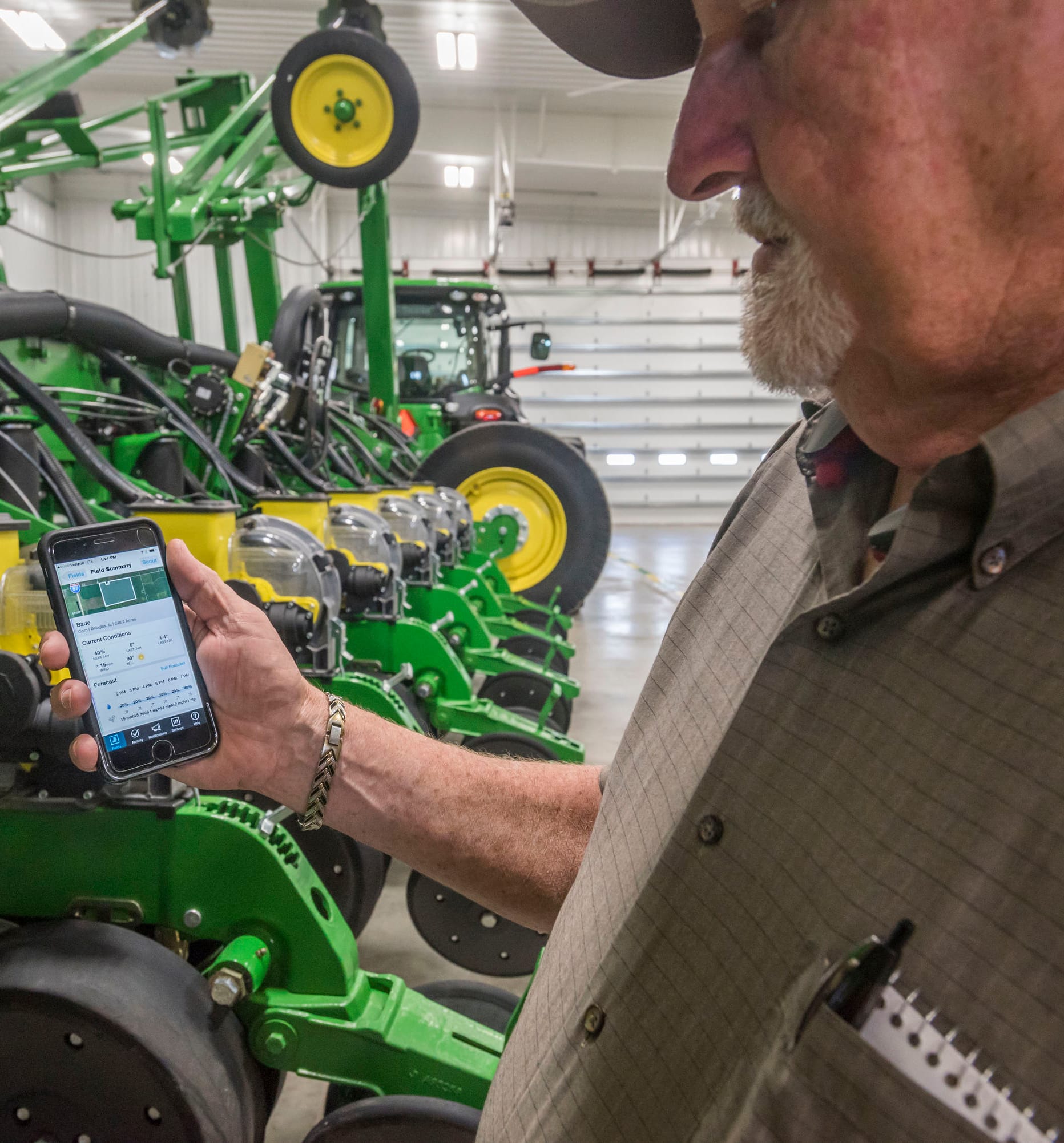 Apgar Farms representative Tom Austin uses a Climate Corporation app on a mobile phone on June 10, 2015.