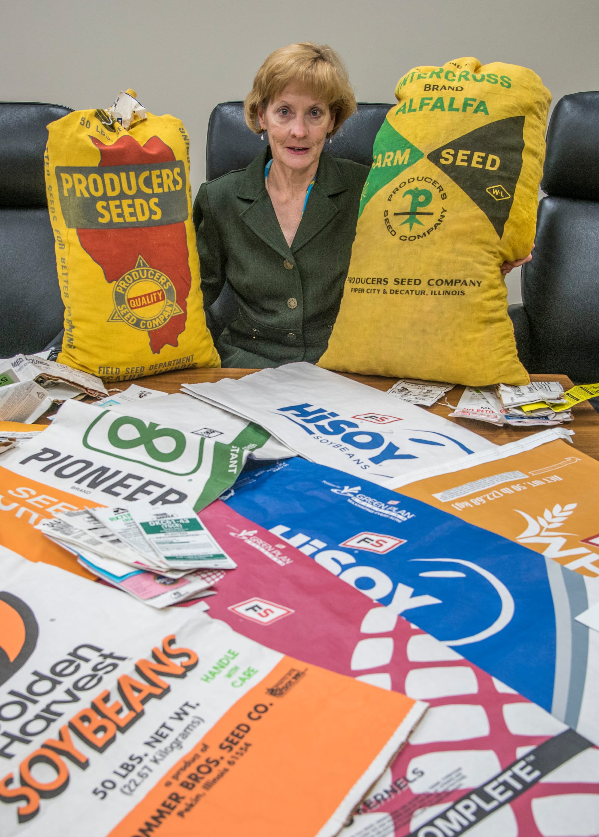 Tamara Nelsen at Illinois Farm Bureau in Bloomington with a variety of seed bags from the past. Wednesday, Oct. 5, 2016.