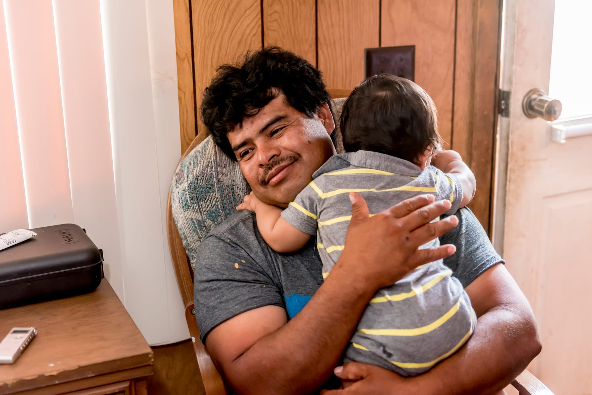 Agustin Chavarria, 41, and his 11 month old baby, Jose, at their temporary home on an orchard just outside of Lexington, Missouri, on June 22, 2016.
