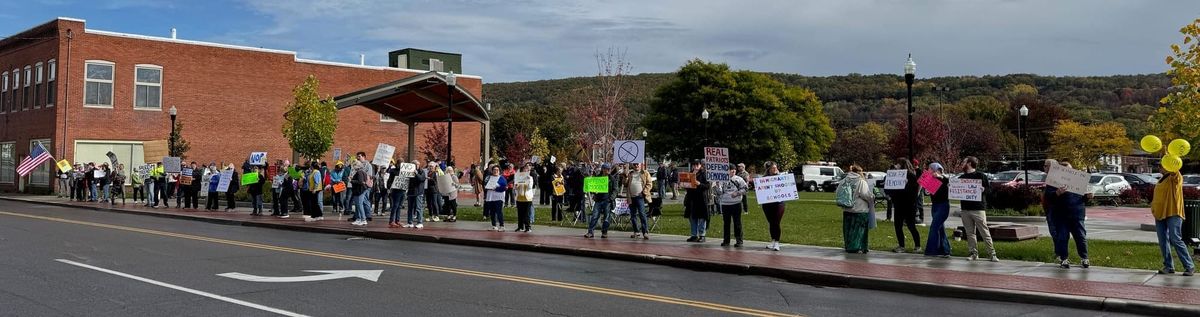 A large crowd of protesters lining a sidewalk.