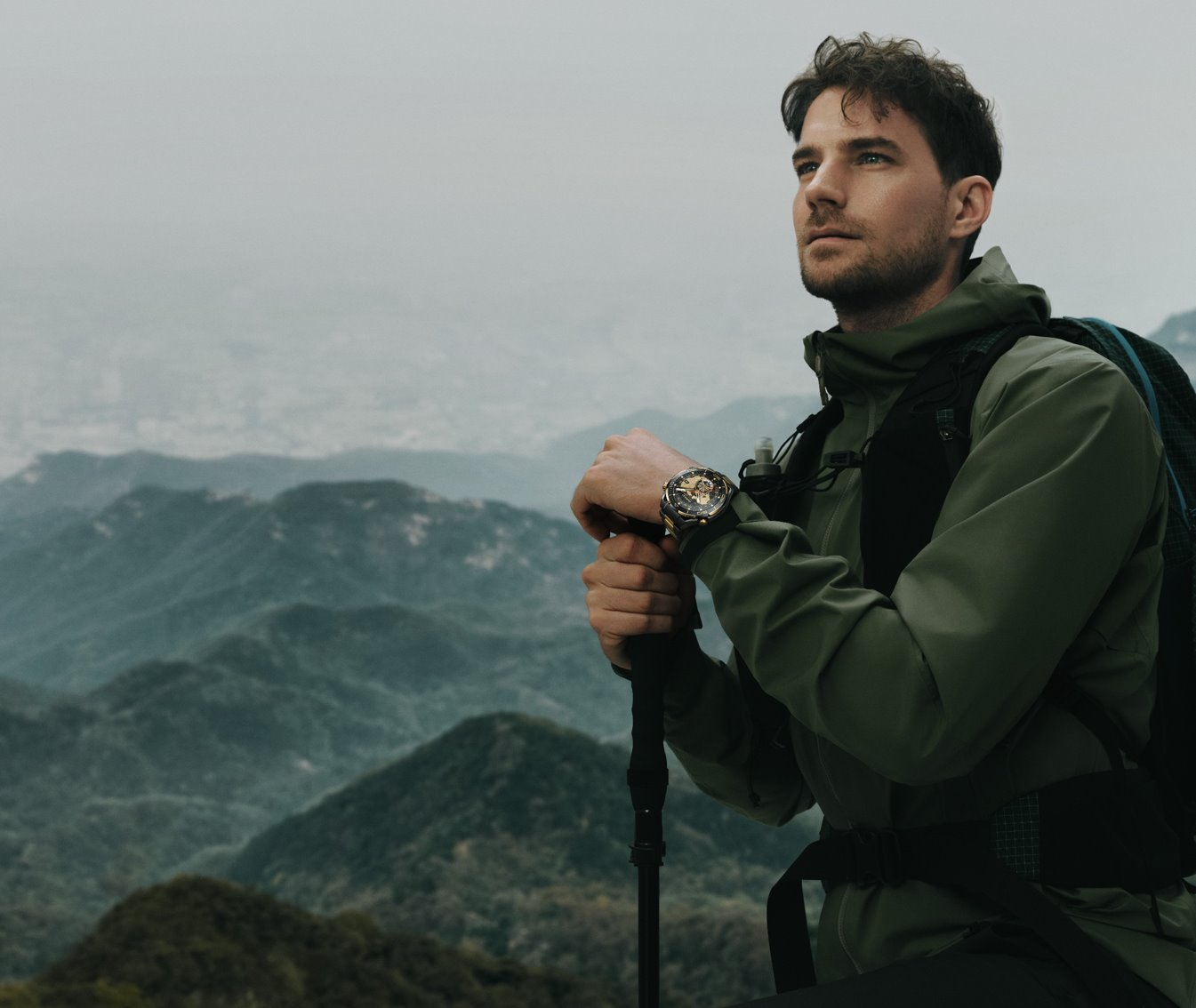A person with a backpack and walking stick
Description automatically generated