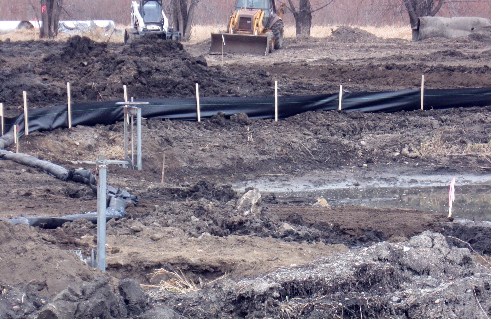 Silt fence and mulch rolls along a graded construction site