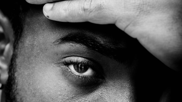 Man looking with hand over forehead