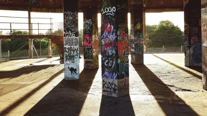 Pillars holding up a building with sunlight shining through.