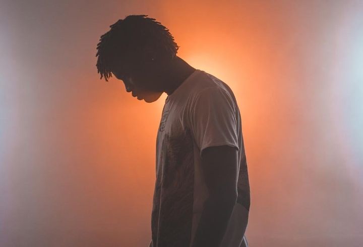 Man looking down standing in the light