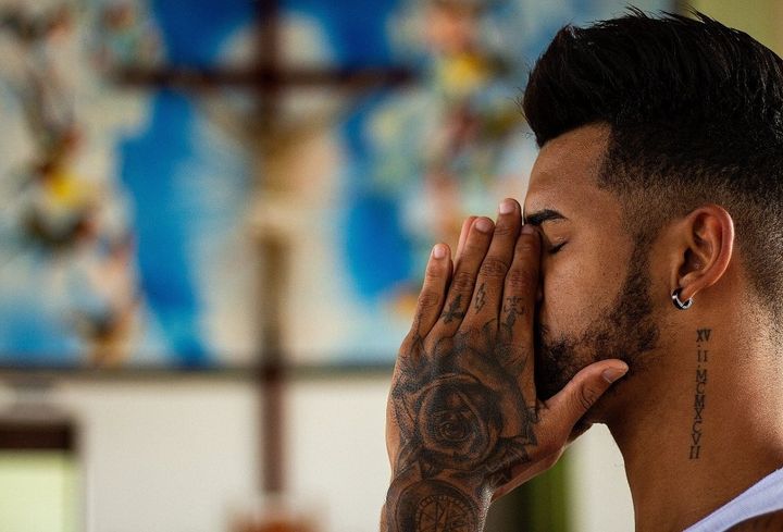 Man praying into his hands