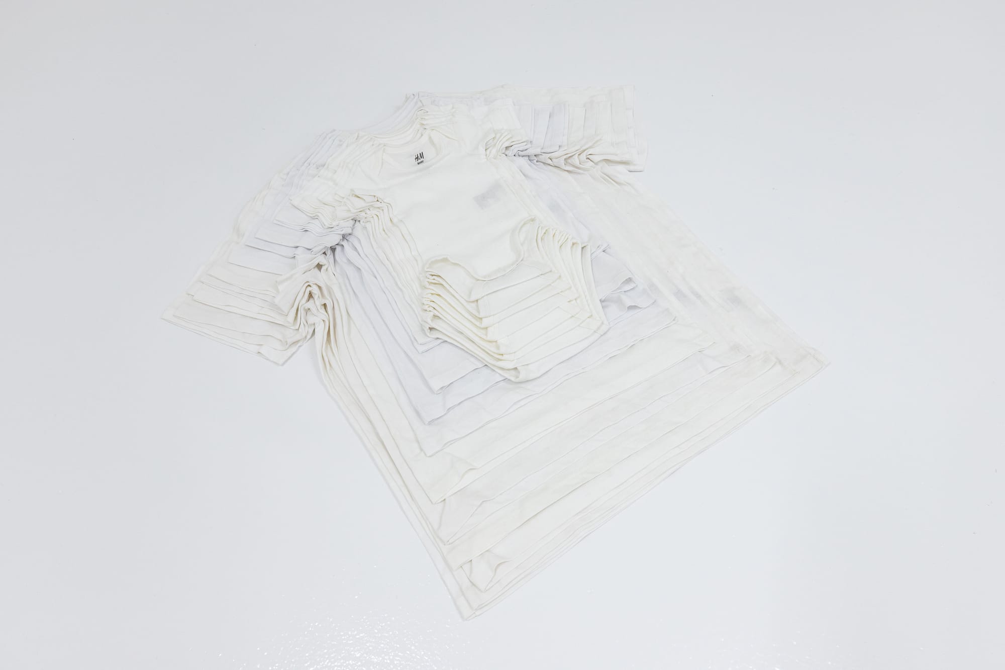 Stephanie Saade’s pyramid growth through layered garments, from infant socks to XXL t-shirts.