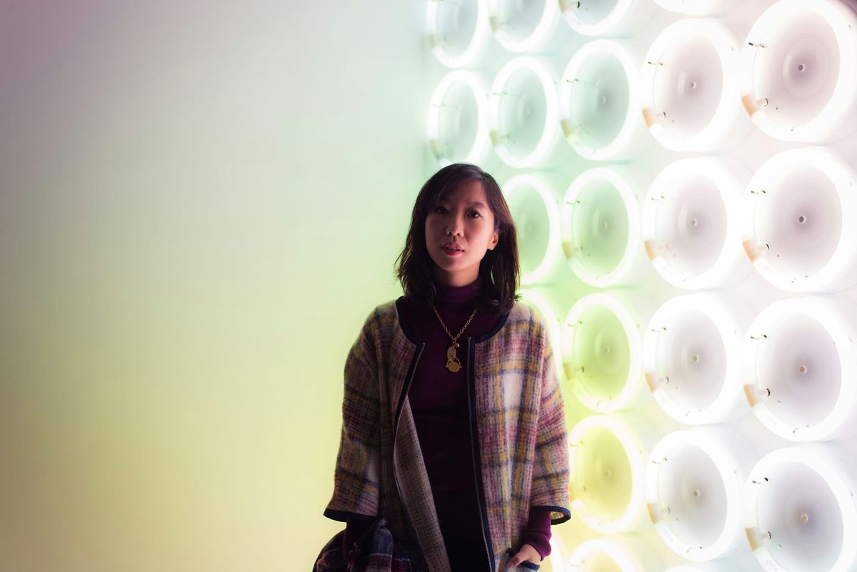 Modern art gallery with visitors interacting with exhibits under strategic lighting.