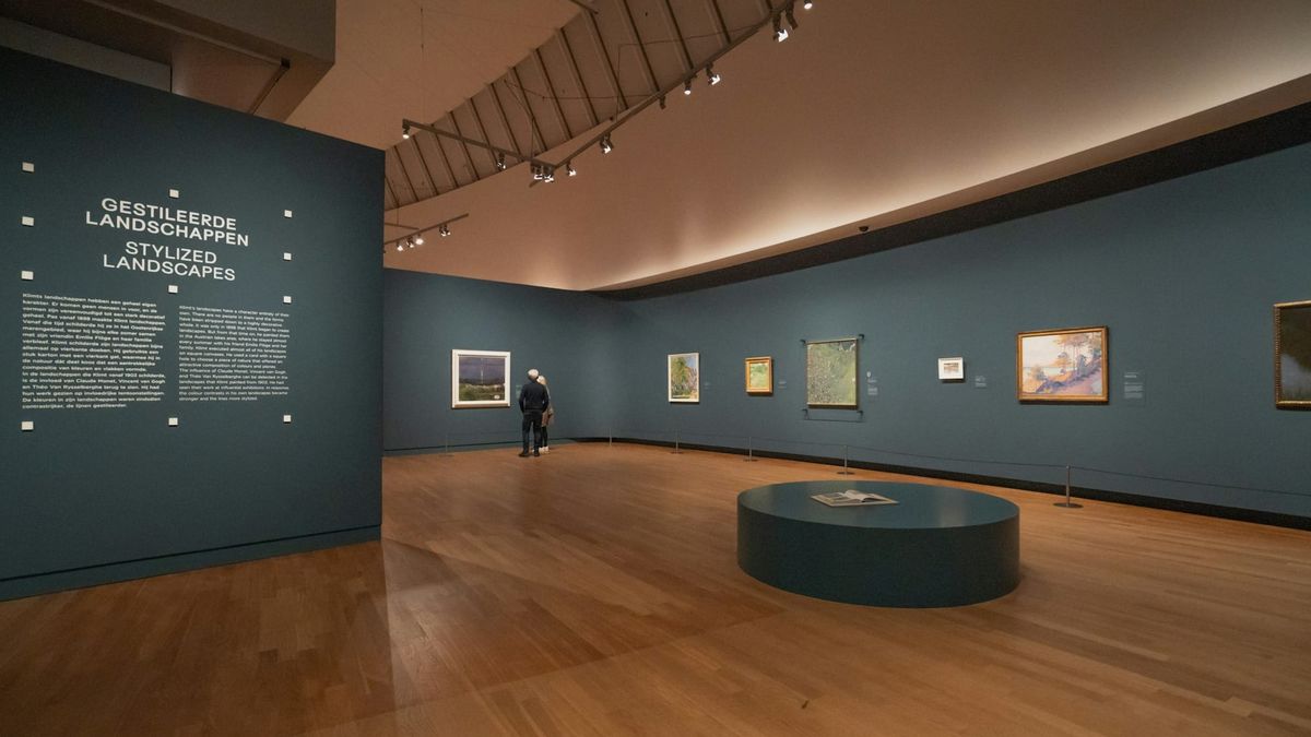 Museum gallery wall with artwork labels positioned beside framed artworks, emphasizing the role of text in shaping viewer interpretation.