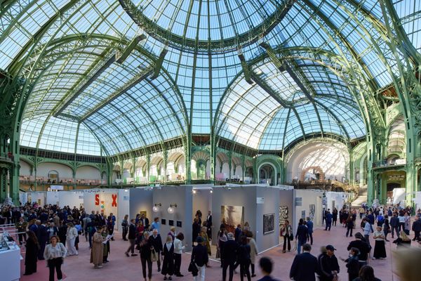 A wide-angle view of the Grand Palais, with its glass-domed ceiling and expansive hall.