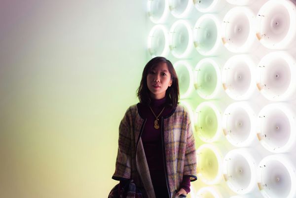 Modern art gallery with visitors interacting with exhibits under strategic lighting.