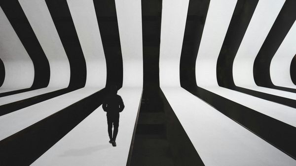 Blackand white forms intersecting and diverging, suggesting structural systems shaping individual paths.