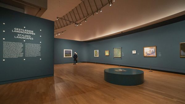 Museum gallery wall with artwork labels positioned beside framed artworks, emphasizing the role of text in shaping viewer interpretation.