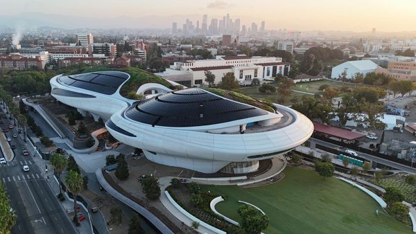 Aerial view of the Lucas Museum of Narrative Art in Exposition Park, Los Angeles, showing the museum’s curved white structure amid surrounding parkland.