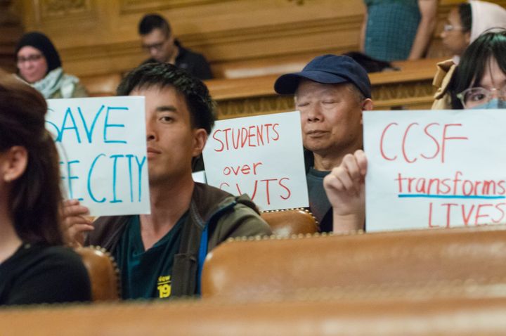 Free City advocates hold up signs at City Hall.