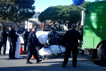 Medical examiners prepare to remove the body of an elderly pedestrian, who was struck and killed by an SFPUC vehicle on Ocean and Miramar avenues on Feb. 9. RAMSEY EL-QARE / THE GUARDSMAN