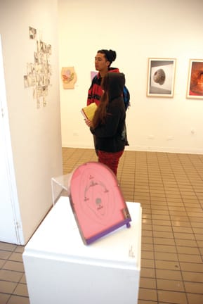 City College students Marissa Juvera and Armand Beltran adminre artwork at the "Pap Art" exhibit at the City Arts Gallery in the Visual Arts Building. JOSEPH PHILLIPS / THE GUARDSMAN
