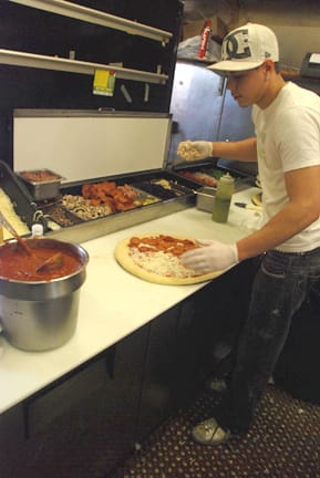 Nilton Goncalves preparesa half beef pepperoni, half barbecue chicken pizza at the San Franciso Seniore's Pizza restaurant. RAMSEY EL-QARE / THE GUARDSMAN