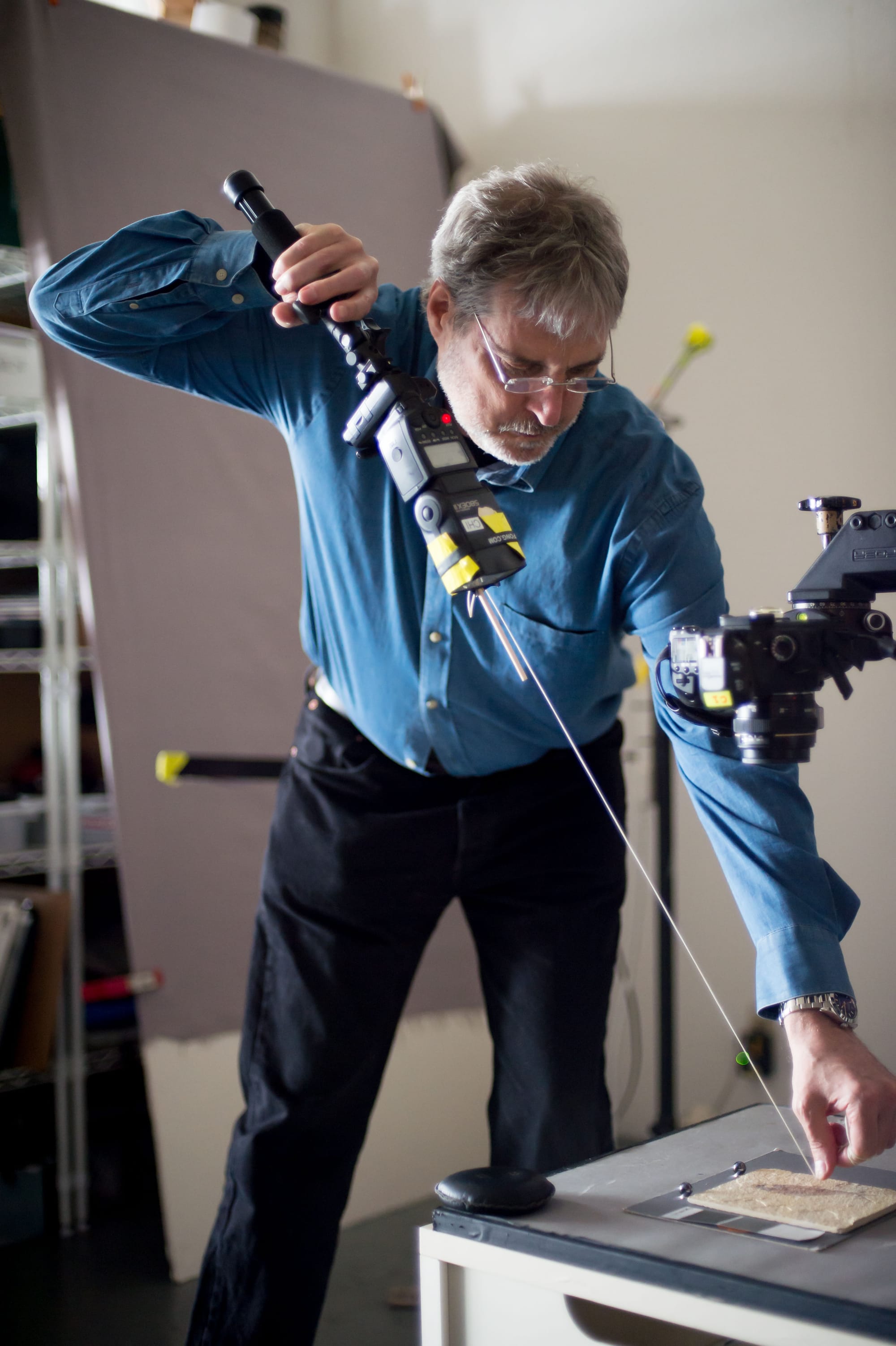 President and board member of Cultural Heritage Imaging Mark Mudge demonstrates Reflectance Transformation Imaging on a fos- silized fish to attendees at its organization’s open house on Sunday, March 22. (Photo by Otto Pippenger)