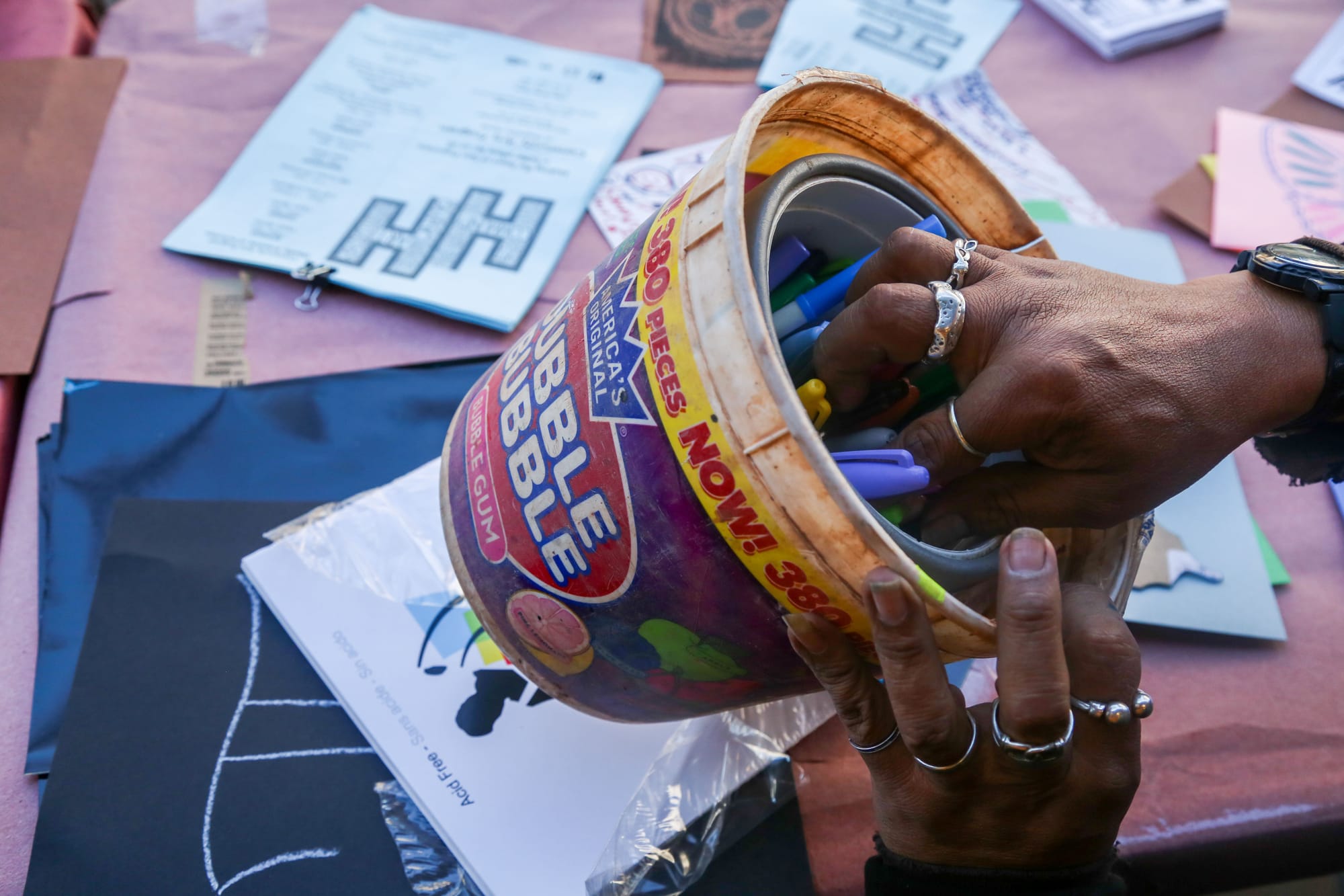  Txutxo Perez reaches into a bucket of markers to draw with at the sidewalk art booth.