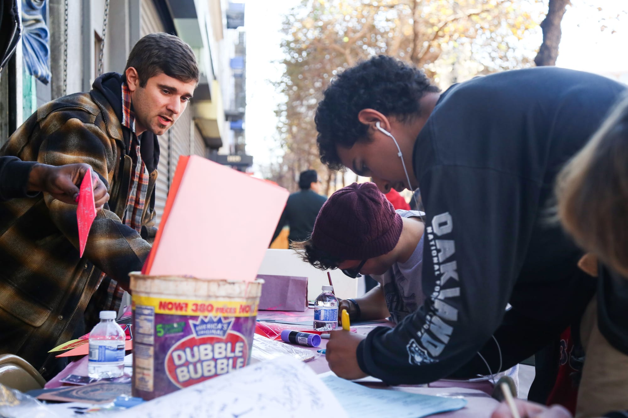  CAP ceramics instructor Josh Reinstein, left, shows passerby how to make relief prints at the sidewalk art table at 1009 Market St.
