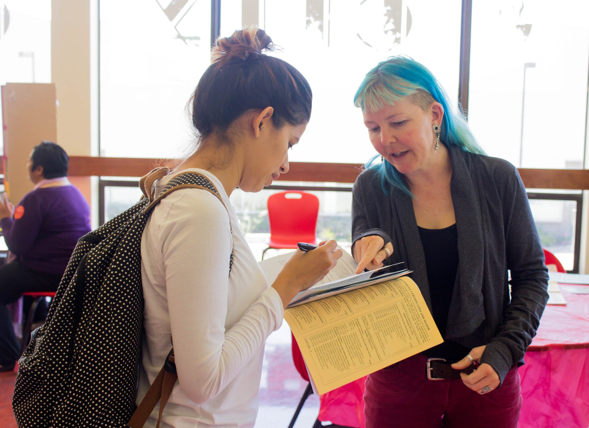 Kamille Hitz, Fashion Department Chair, shows CCSF Student Diana Cruz all the different fashion classes and they can benefit her.