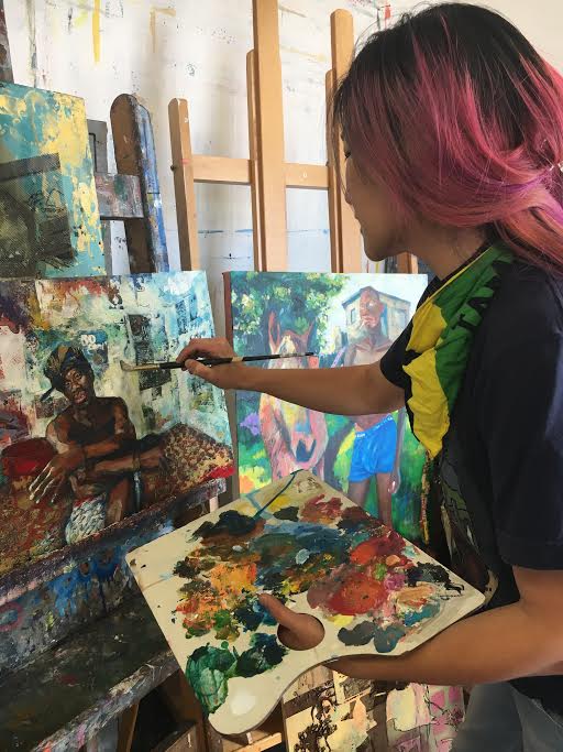 Tsungwei Moo holds her palette as she works on a painting of her late boyfriend Ricardo Distin on October 2, 2017. Photo by Laurie Maemura. 