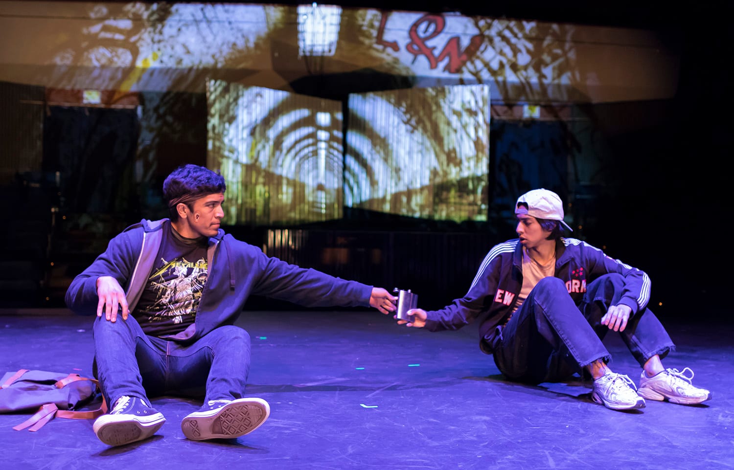  Pascal (Eduardo Soria) hands a flask of juice to Anon (Marco Lemus) while hanging out in the underground tunnel in Naomi Iizuka’s Anon(ymous). October 12, 2017. (AP Photo/Cat Pimentel) 