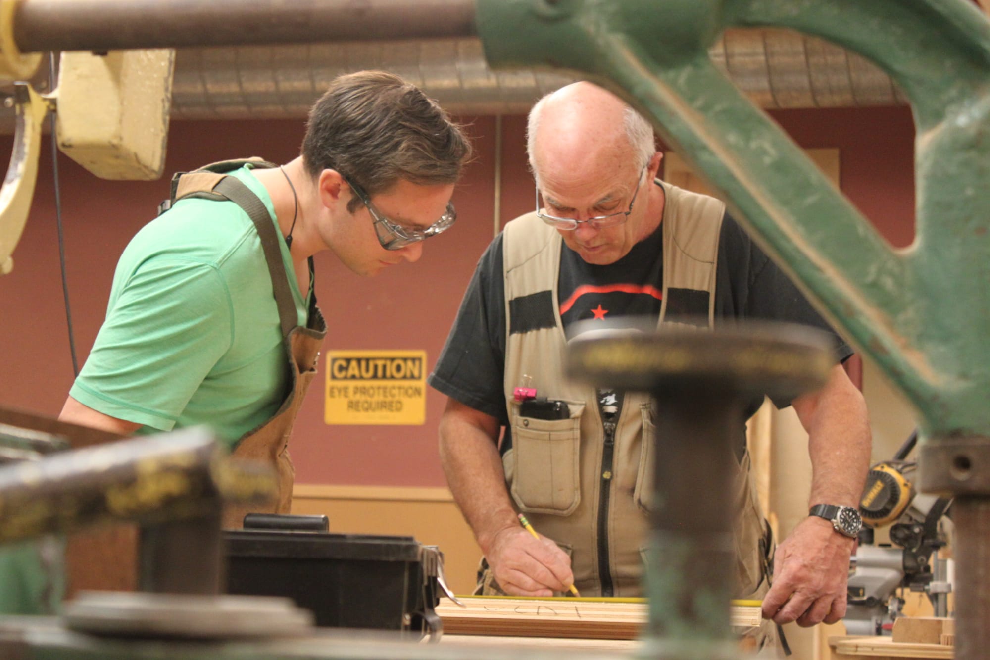 Pursuing carpentry as a passion, Cem Turhal is working with his teacher, Raymond Cash, to measure and mark a piece of pine wood for his project. Cash has over 30 years of experience that he offers to City College students. Photo taken by Bethaney Lee on Nov. 6, 2017. 