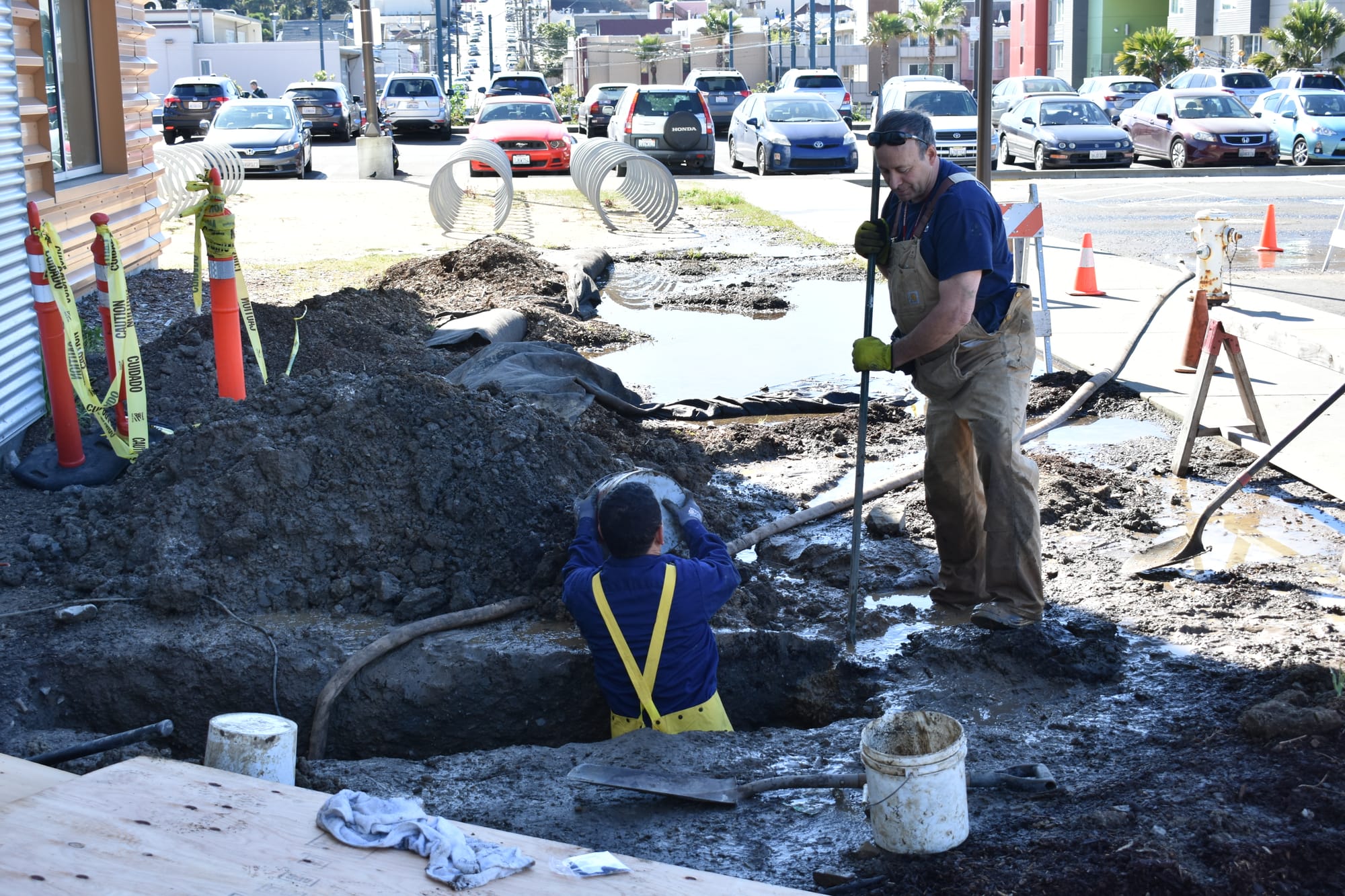(L-R) ACC Engineering Systems Plumber Jose Lopez and a man who goes by Dave The Plumber dig a hole to uncover the source of a water leak at the Ocean Campus Multi-Use Building (MUB) on Feb. 15, 2018. Photo by Michael Menaster/The Guardsman.