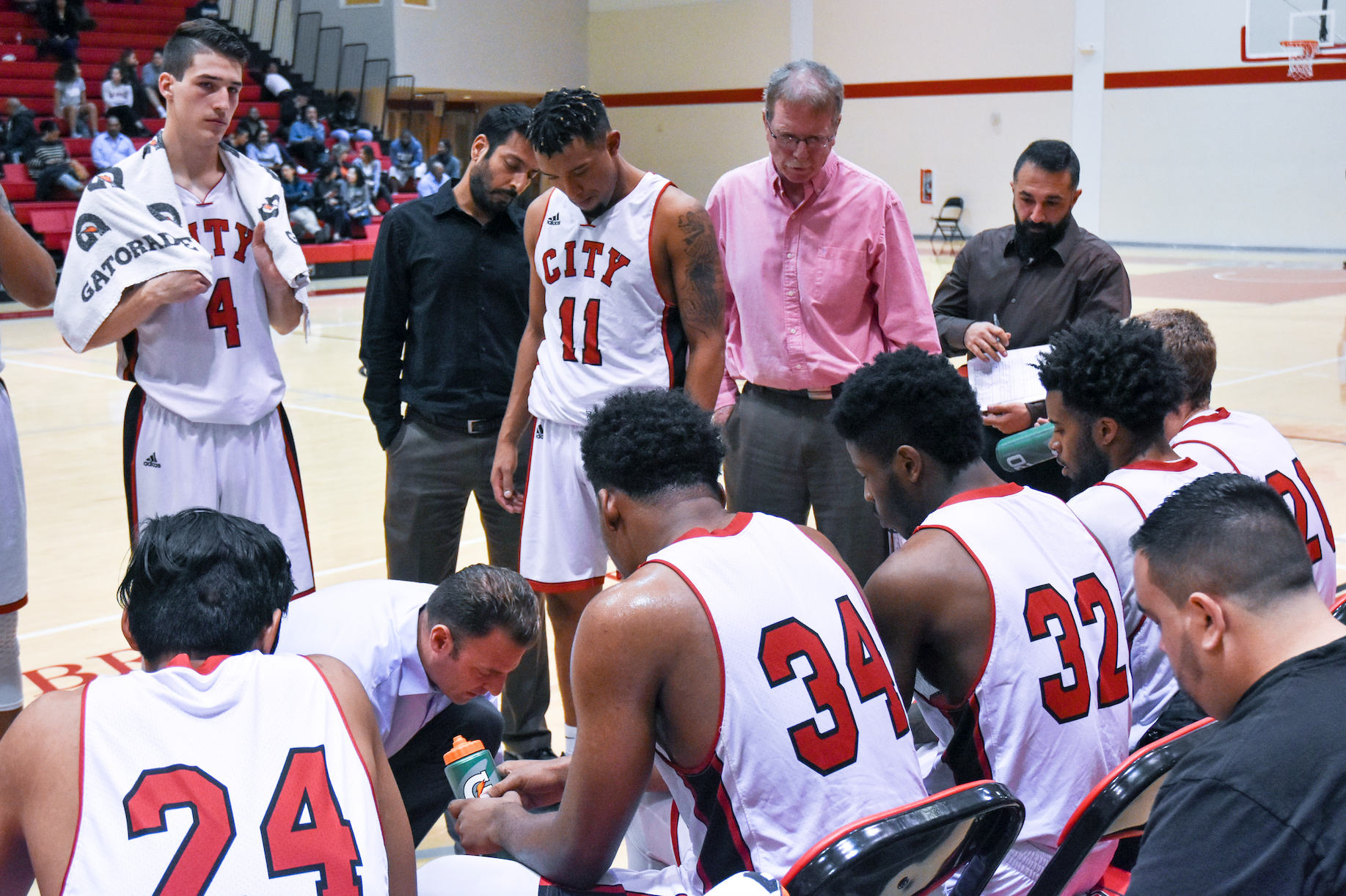 Ram's Head Coach Justin Labagh gathers men's basetball team around to run a design play against Ohlone College on Feb. 16, 2018. Photo by Michael Menaster/special to The Guardsman.