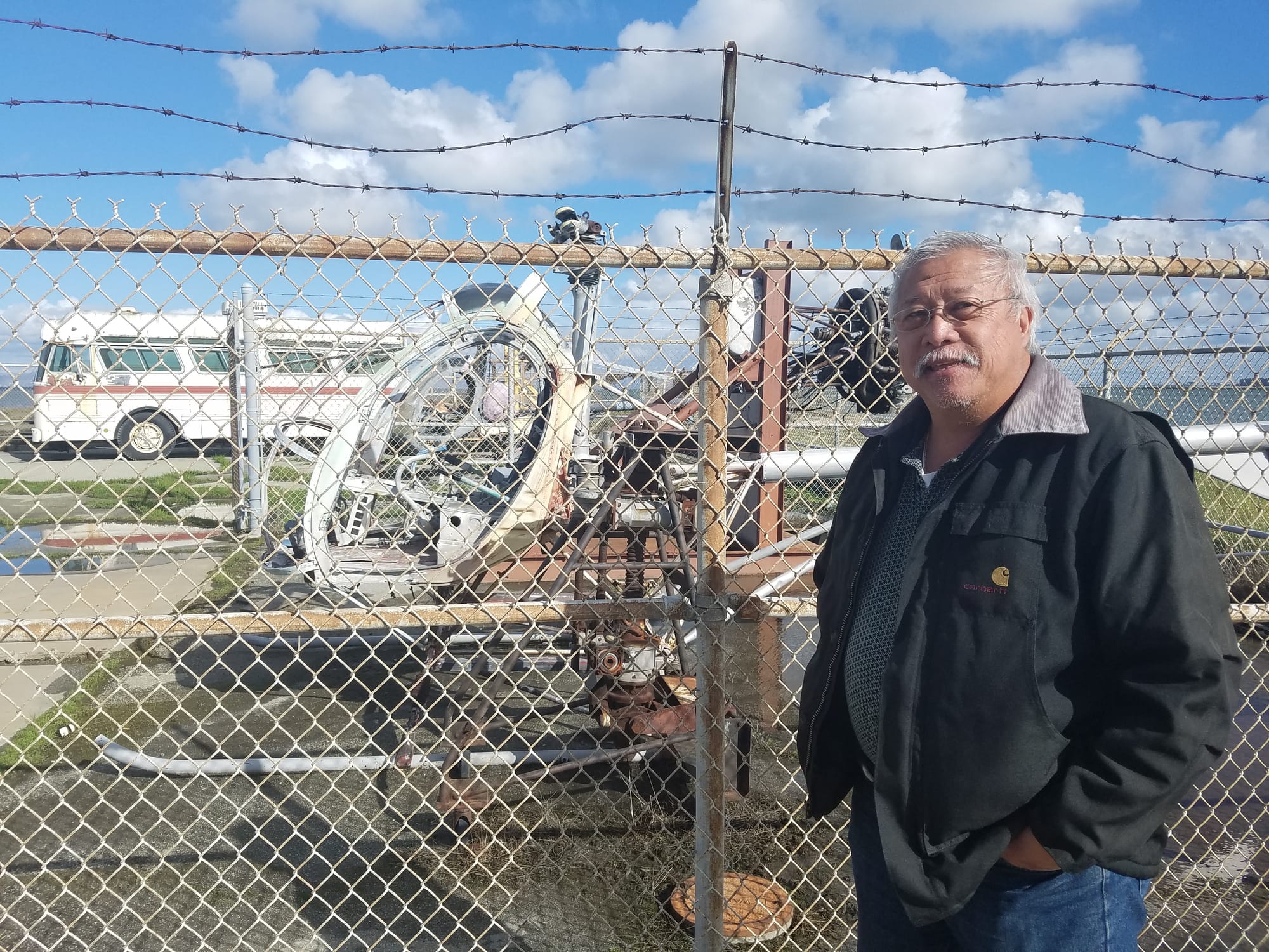 Edmund G. Dea, a fire science and technology instructor, stands in front of a decommissioned helicopter at the Airport Campus on March 16, 2018. Photo by Cameron Ehring/The Guardsman.