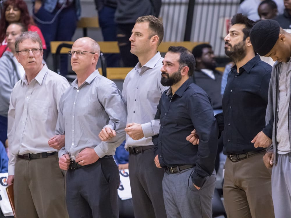 Assistant Coaches Tom McNichol (left to right), Adam D'Acquisto, Head Coach Justin Labagh (center), Nima Shaahinfar, and Ravi Bhambhra lock arms during CCCAA State Title game. Photo by Peter Wong/Special to The Guardsman.